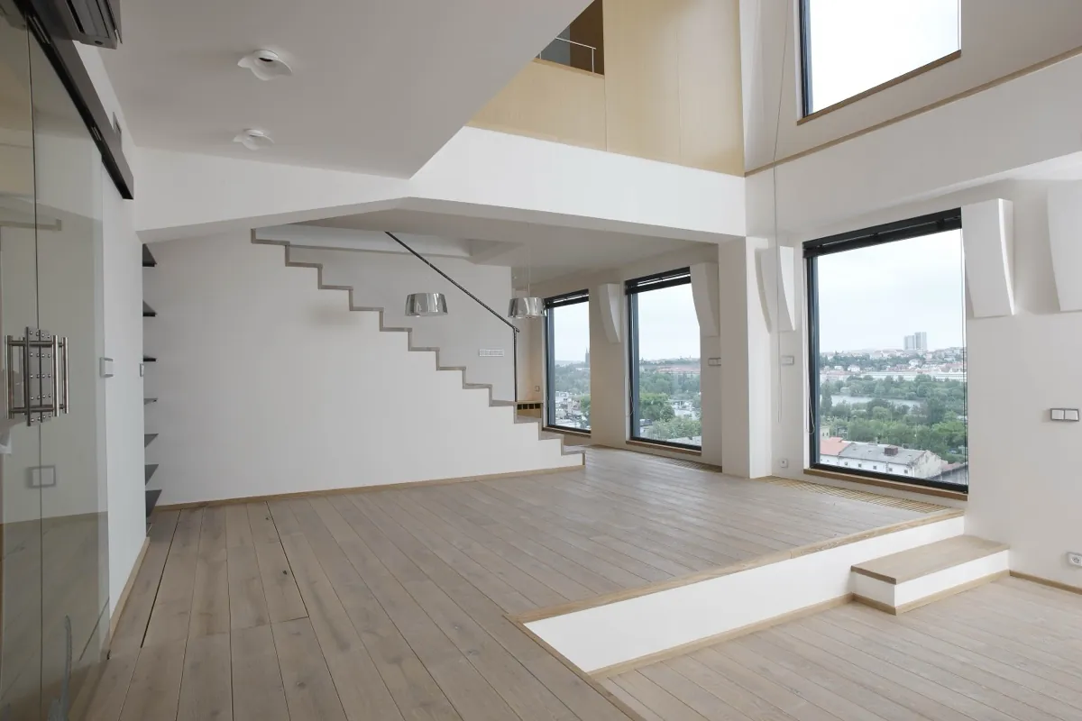 Světlý loft se schodištěm a velkými okny